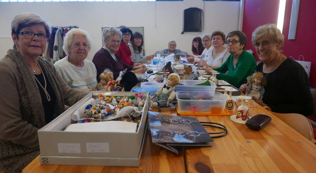 Eine Gruppe von älteren damen an einem Tisch mit Bastelsachen